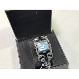 A white metal Gucci lady's wristwatch with horsebit double strap and mother of pearl square dial