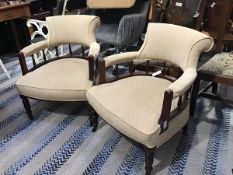 A pair of Edwardian walnut horseshoe back tub chairs with upholstered panel backs, arms and seat, in