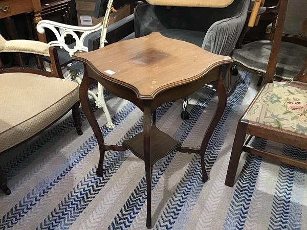 An Edwardian mahogany shaped top two tier occasional table, raised on square tapered supports (h.