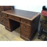An Edwardian walnut twin pedestal kneehole desk, the rectangular top with inset skiver and moulded