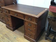 An Edwardian walnut twin pedestal kneehole desk, the rectangular top with inset skiver and moulded