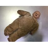 A 1930s moulded plastic headed child's muscial doll with plush body and stuffed legs (31cm x 14cm)