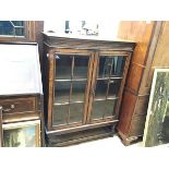 An oak bookcase, the rectangular top with antique finish and moulded edge above a carved narrow