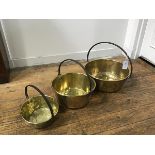 A set of three late 19thc/early 20thc brass preserve pans with cast iron loop handles (smallest: h.