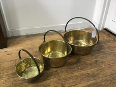 A set of three late 19thc/early 20thc brass preserve pans with cast iron loop handles (smallest: h.