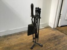 A wrought iron companion set comprising a poker, tongs, associated shovel and brush (h.59cm)