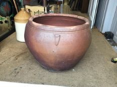 A large terracotta high fired glazed ovoid tapered garden pot with applied leaf style moulded detail