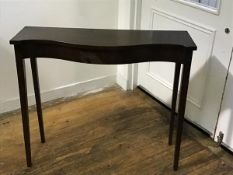 An Edwardian neat mahogany serpentine front side table, the top with moulded edge and plain