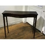 An Edwardian neat mahogany serpentine front side table, the top with moulded edge and plain