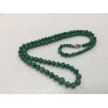 A green jadeite graduated bead necklace (largest bead approx:7mm) (l.29cm)