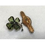 A yellow metal mounted four leaf green stone set shamrock with seed pearls (one pearl missing) (d.