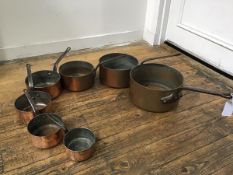 A set of late 19thc copper graduated cast iron handled pans, (sized d. 14cm 16cm 18cm 20cm 24cm