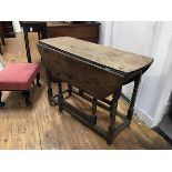 A 17thc oak drop leaf table, with twin drop flaps, on turned bobbin supports, united by moulded