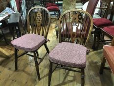 A pair of oak and elm Windsor style pierced splat and spar back kitchen chairs with shaped wood