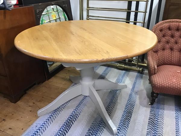 A Marks & Spencer solid oak top Moss-Putty extending circular dining table, raised on turned