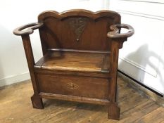 A 1920s/30s oak stick stand with panel shaped back, with lift up box seat and twin stick/umbrella