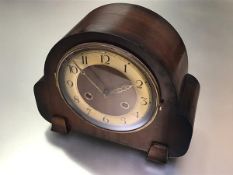 A vintage Deco walnut chiming mantle clock with silvered dial, twin key apertures and arabic