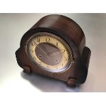 A vintage Deco walnut chiming mantle clock with silvered dial, twin key apertures and arabic