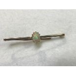 A yellow metal knife edge bar brooch mounted oval water opal in claw setting (approx 0.75ct) (1.