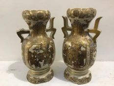 A pair of Satsuma baluster two handled vases decorated with figures, courtiers etc. enclosed