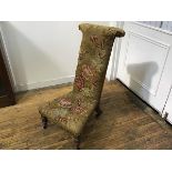A Victorian walnut framed prie dieu chair with tapestry rose decorated upholstered panel back and