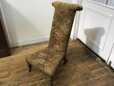 A Victorian walnut framed prie dieu chair with tapestry rose decorated upholstered panel back and