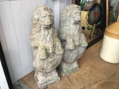 A pair of moulded composition stone heraldic style rampant lion figures holding shields (h.74cm x