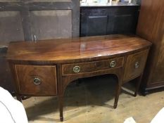 A George III mahogany bow front sideboard, the top with moulded edge above a centre frieze drawer,