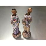 A pair of 19thc Continental bisque Chinese standing figures with nodding heads mounted on springs,