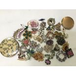 A mixed lot comprising two compacts, a collection of spray brooches, Christmas enamelled brooches, a
