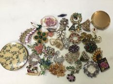 A mixed lot comprising two compacts, a collection of spray brooches, Christmas enamelled brooches, a