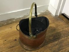 An Edwardian hammered brass swing handled coal helmet, complete with smokeless coal (h.24cm x 27cm)