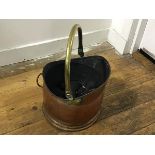 An Edwardian hammered brass swing handled coal helmet, complete with smokeless coal (h.24cm x 27cm)