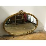 A Regency style oval gilt composition wall mirror with ribbon surmount (62cm x 81cm)