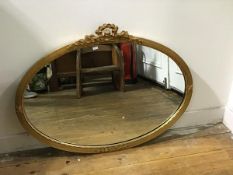 A Regency style oval gilt composition wall mirror with ribbon surmount (62cm x 81cm)