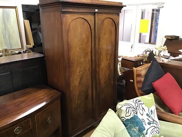 A handsome 19thc mahogany wardrobe, the moulded cornice above a pair of arched inset panel doors