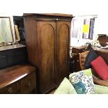 A handsome 19thc mahogany wardrobe, the moulded cornice above a pair of arched inset panel doors