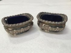 A pair of Birmingham silver salts with chased borders, complete with blue glass liners (h.3cm x l.