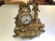 A French 19thc gilt painted metal drum head clock with figure surmount, a Boy on a Barrel, in rococo