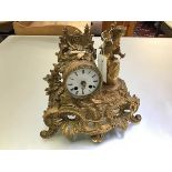 A French 19thc gilt painted metal drum head clock with figure surmount, a Boy on a Barrel, in rococo