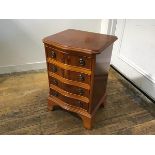 A yew wood miniature serpentine chest, the top with moulded edge above four long drawers, on bracket