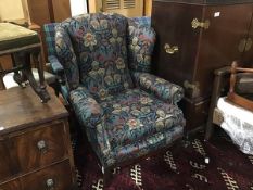 A mahogany framed wing easy chair upholstered in Liberty print fabric, with squab cushion, on square
