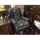 A mahogany framed wing easy chair upholstered in Liberty print fabric, with squab cushion, on square