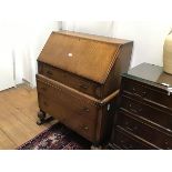 An oak bureau, the rectangular top with moulded edge above a fall front fitted four long drawers,
