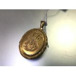 A Victorian yellow metal oval locket with cypher S (l.6cm including loop x 3cm) (unmarked)
