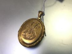 A Victorian yellow metal oval locket with cypher S (l.6cm including loop x 3cm) (unmarked)