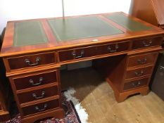 A yew wood reproduction twin pedestal kneehole desk, the top with inset leather skiver and centre