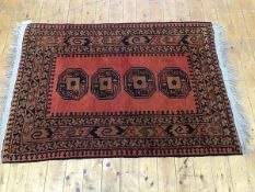 An Iranian rug, the centre panel with four stylised octagons enclosed within a running dog and