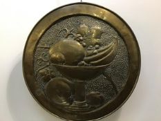 An Arts & Crafts brass charger depicting a rare still life scene of a bowl of fruit. Circa 1901