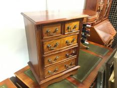 A mahogany miniature chest, the serpentine top above two short and three long drawers, on plinth